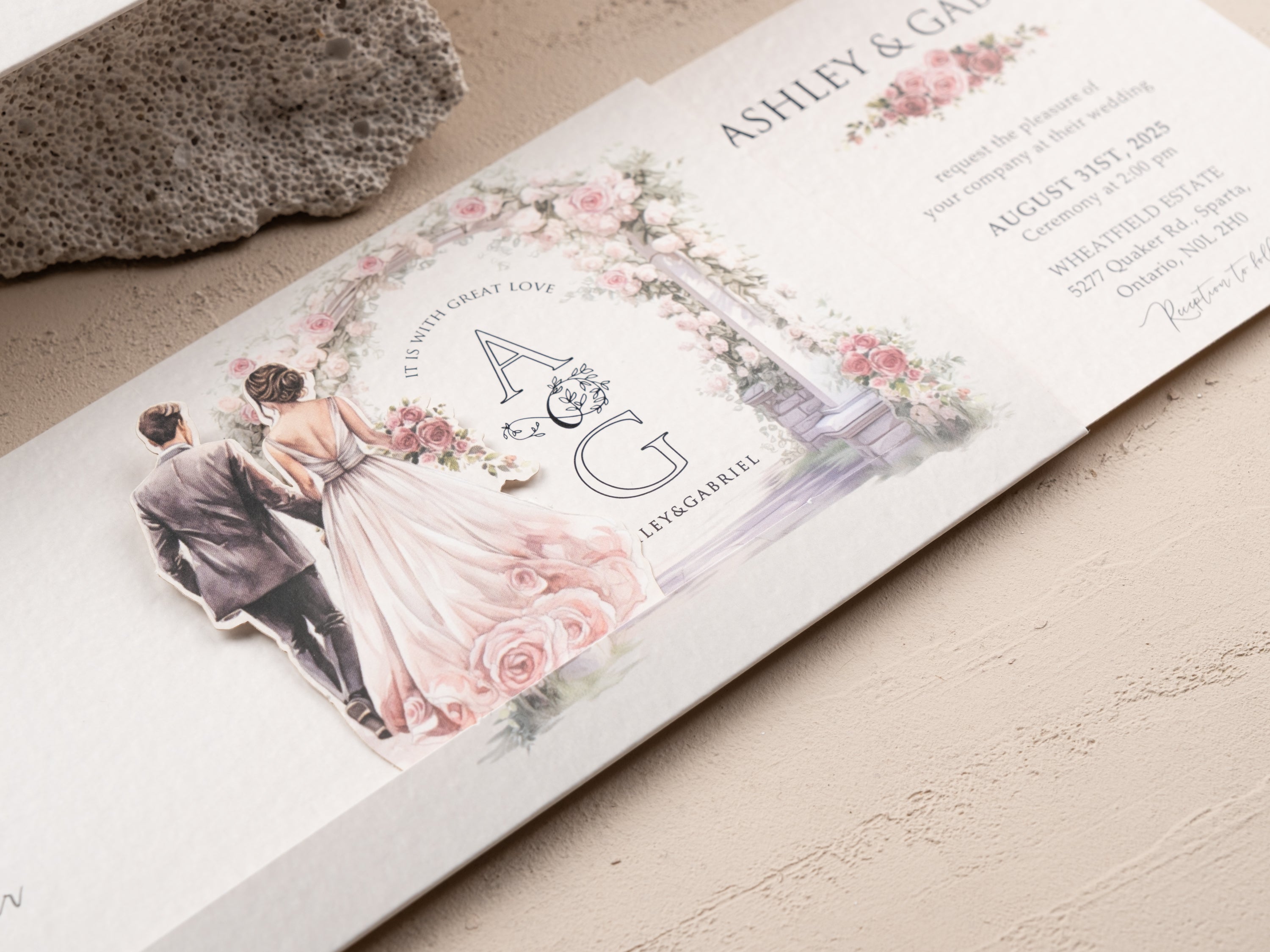 Close-up of floral arch sliding wedding invitation featuring custom A & G monogram and romantic watercolor artwork.