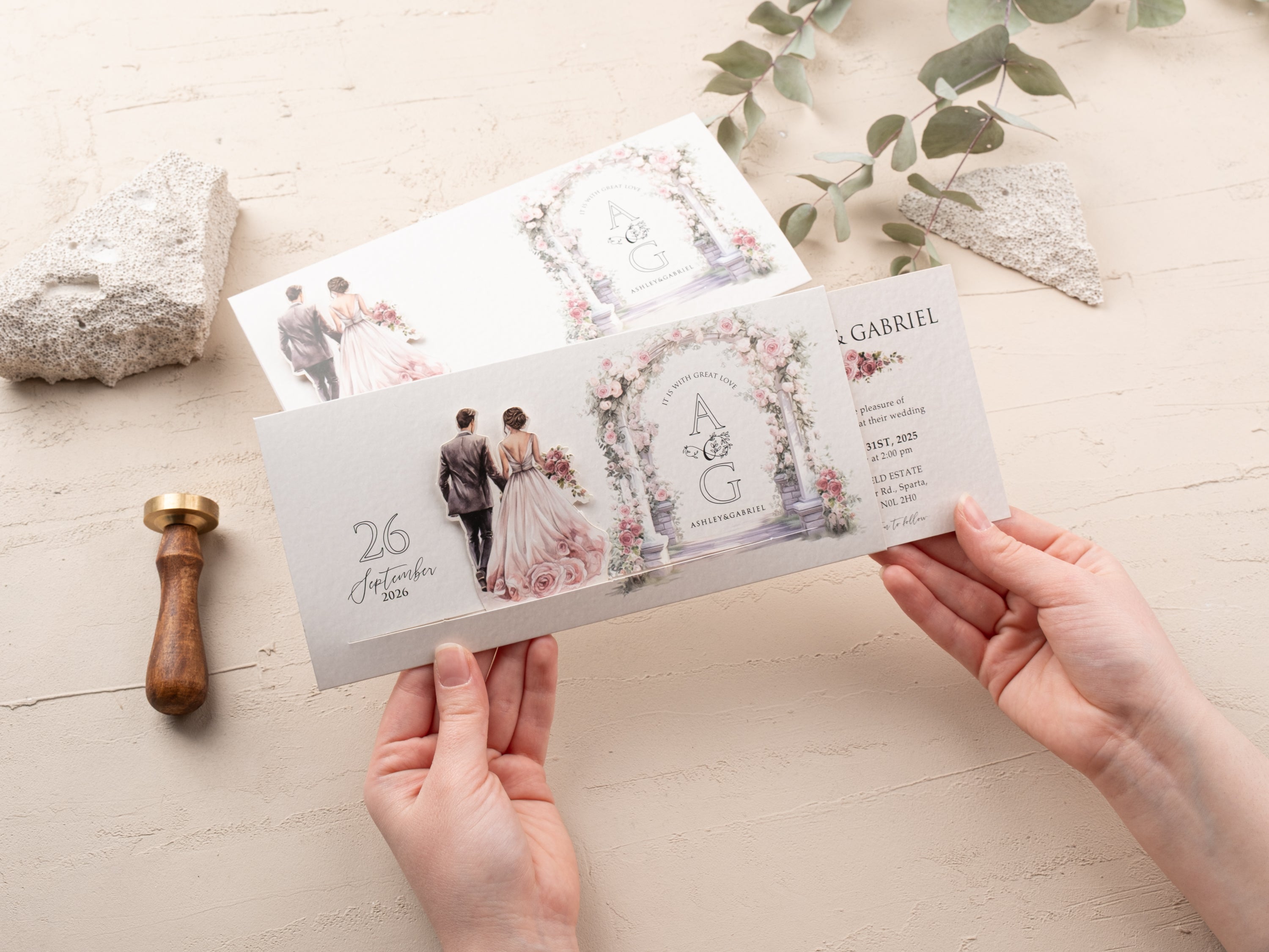 Person sliding open a romantic floral wedding invitation revealing ceremony details and floral arch illustration.