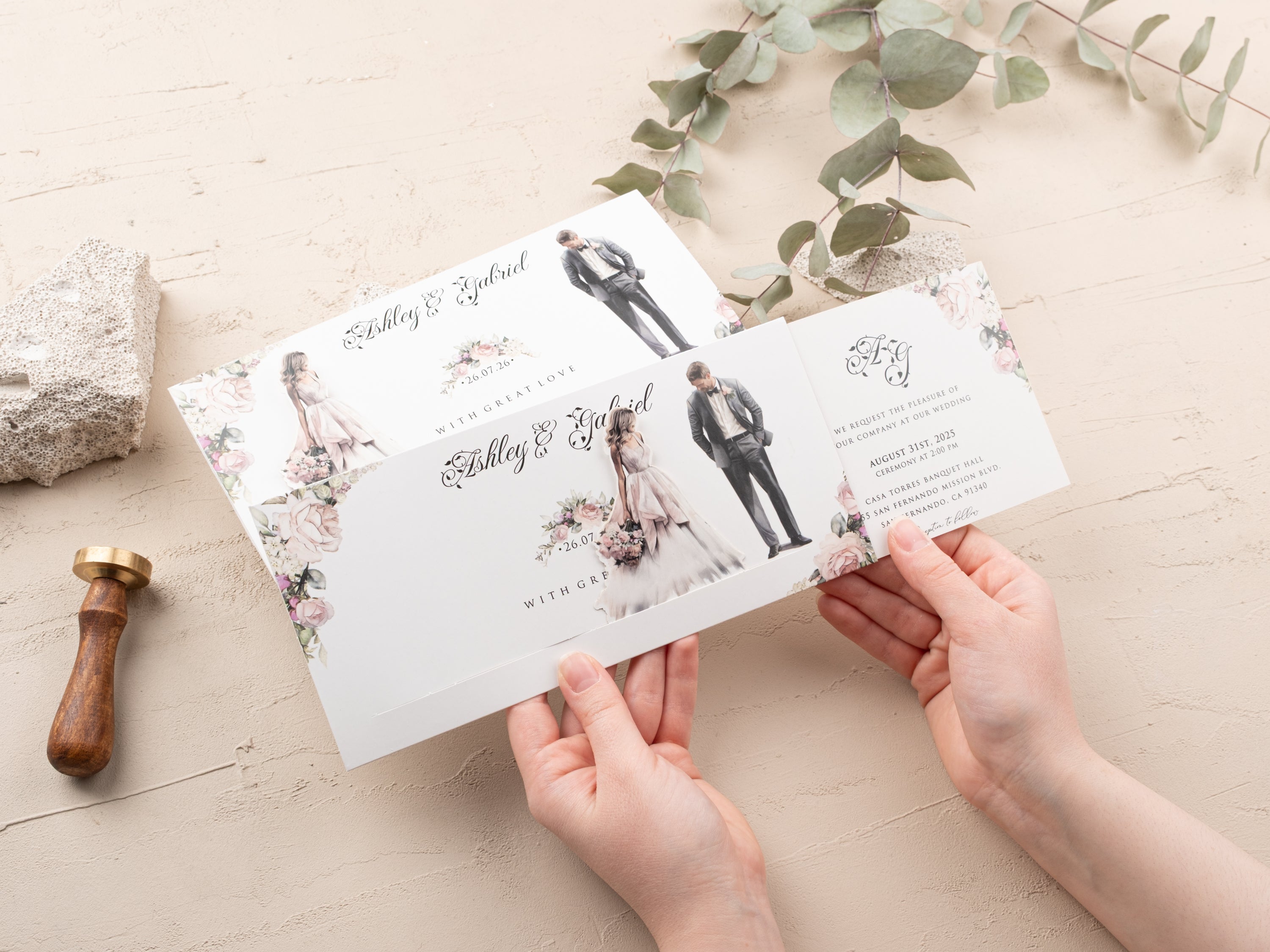 Person opening an elegant sliding wedding invitation with classic floral design and illustrated couple.
