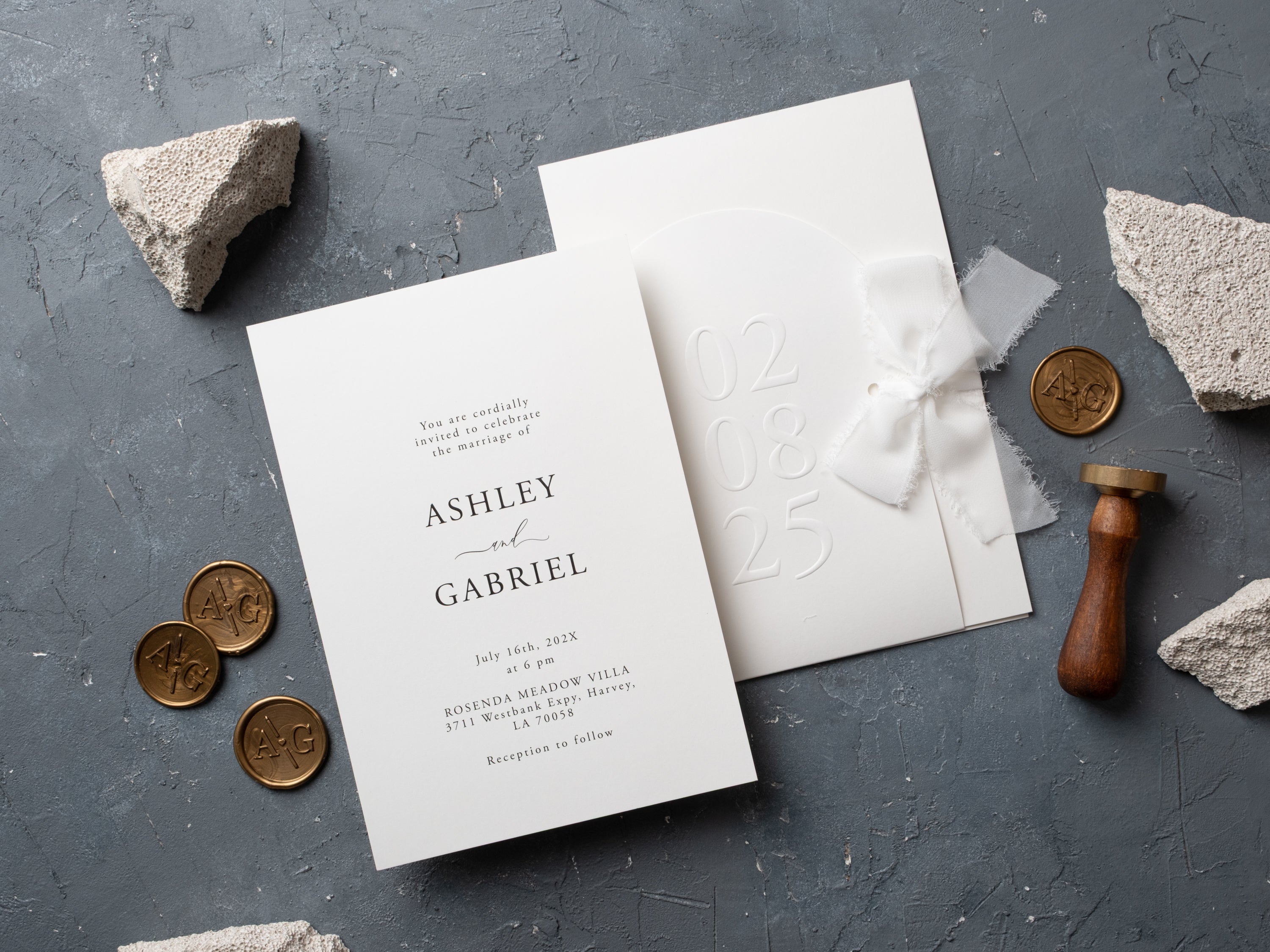 Minimalist embossed wedding invitations with ribbon on textured background