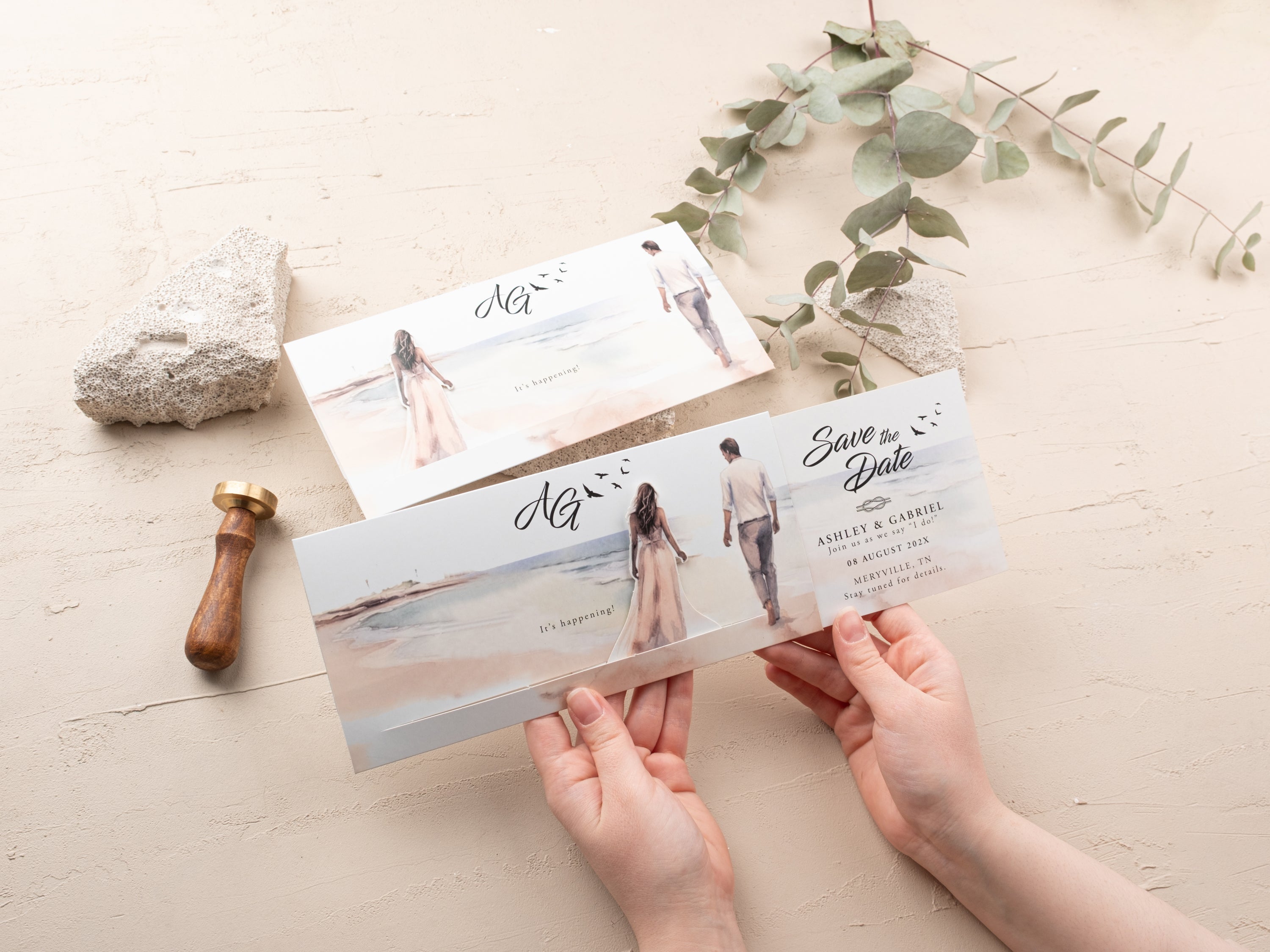 Person opening a sliding save the date card with watercolor beach artwork and customizable wedding details.
