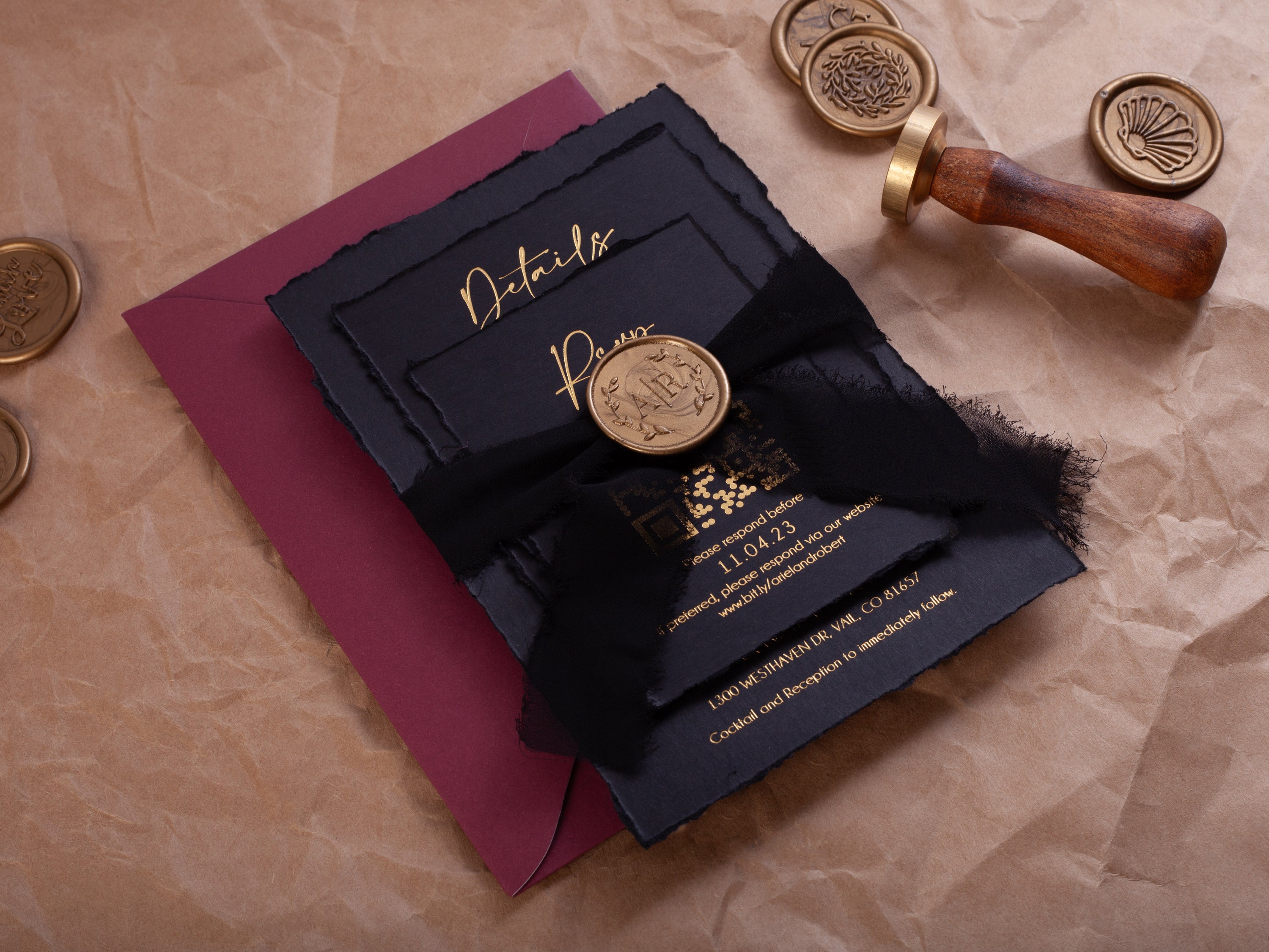 Black and gold deckle edge wedding invitation suite with wax seal, black ribbon, burgundy envelope, and QR RSVP card by World of Wedding Co.