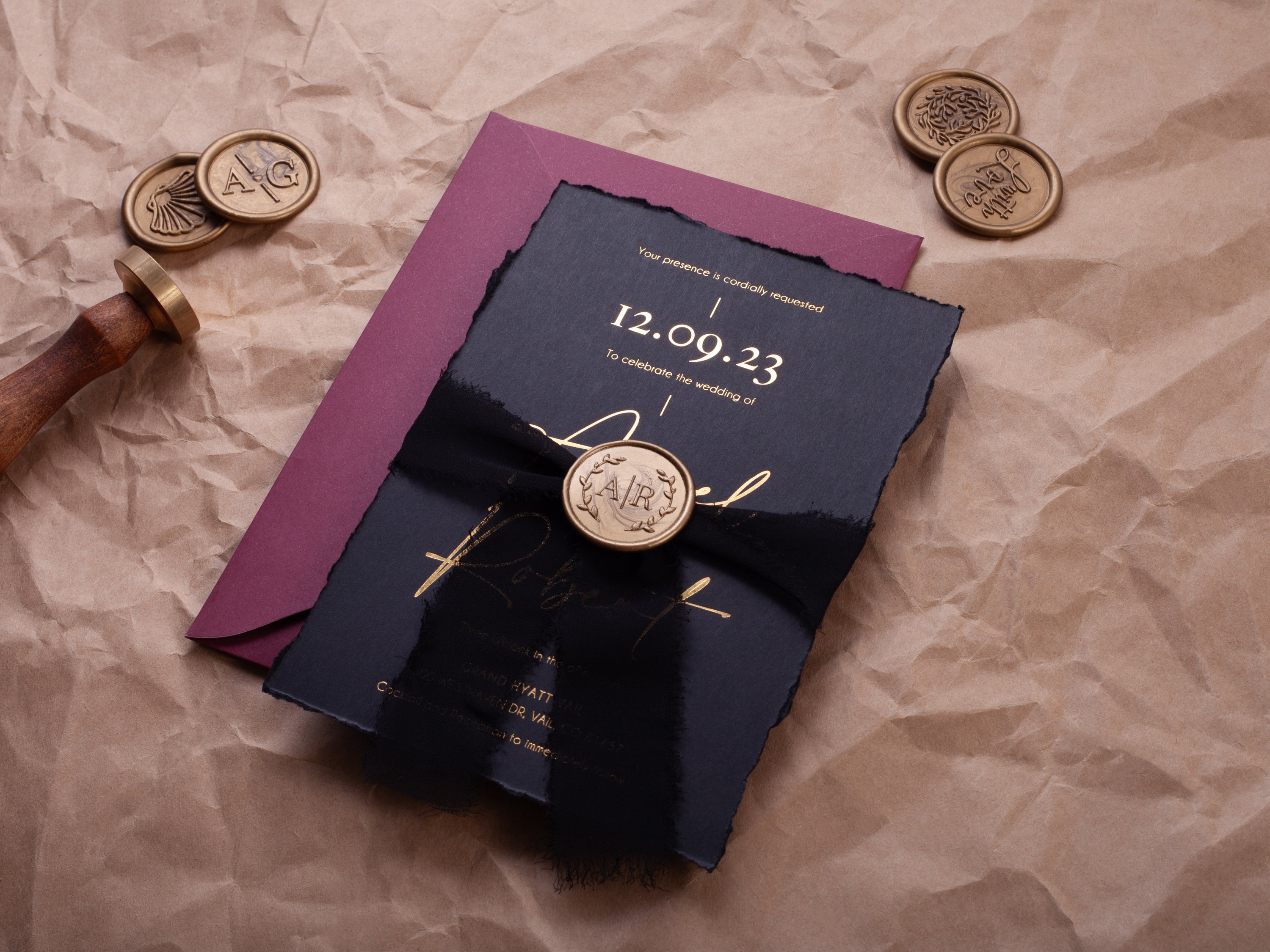 Black and gold deckle edge wedding invitation suite with wax seal, black ribbon, burgundy envelope, and QR RSVP card by World of Wedding Co.