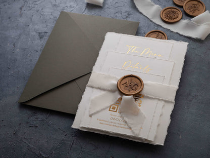 Deckled edge wedding invitation set assembled with ribbon and wax seal